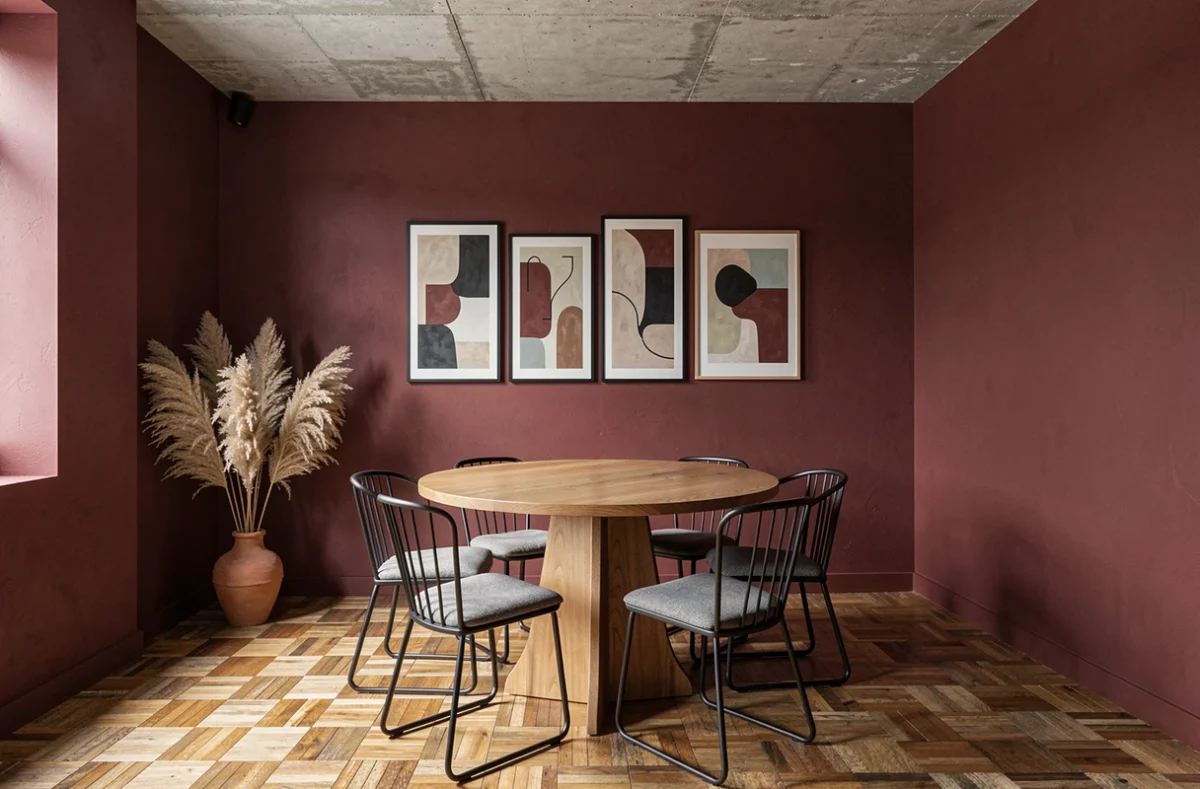 Salle à manger moderne avec un mur peint en bordeaux mat, table en chêne et chaises noires minimalistes